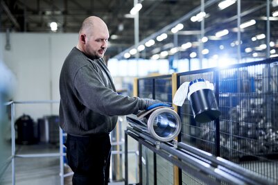 Schiedel Mitarbeiter poliert Abgasrohr in Schiedel Produktionstätte