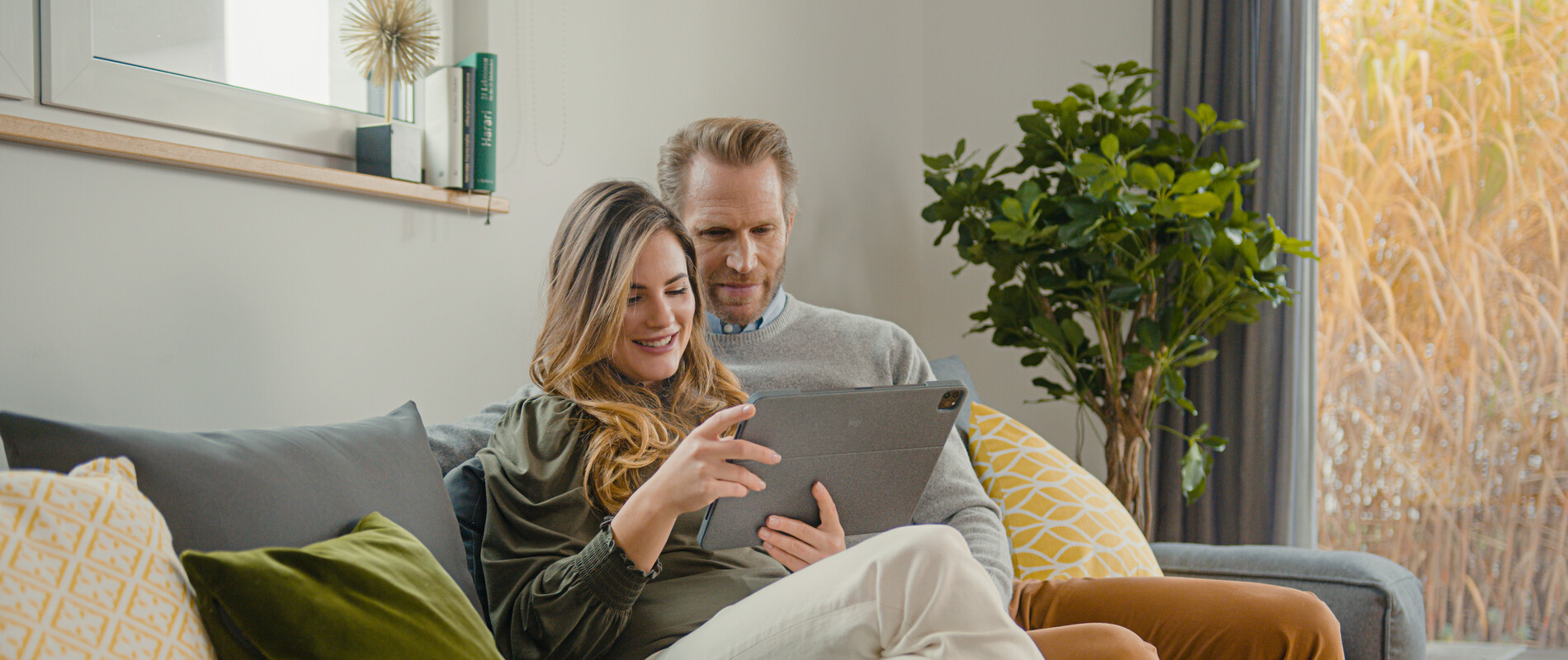 To personer som sitter i en sofa og ser på Schiedel sin nettside